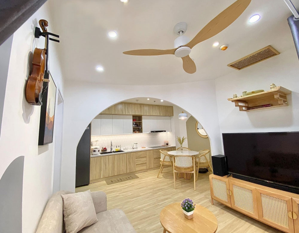 Trong mẫu thiết kế nội thất căn hộ chung cư 60m2 phong cách Vintage Hàn Quốc phòng khách thông với bếp thông qua khung tường hình mái vòm 