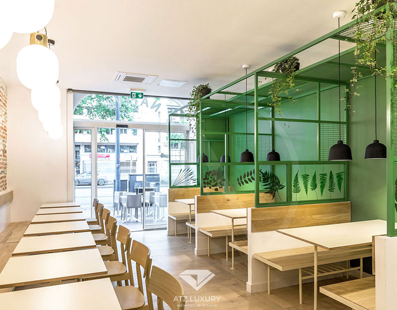 Mẫu 6: Mẫu nhà hàng bình dân phong cách hiện đại với màu trắng chủ đạo, tạo điểm nhấn ấn tượng với gam màu xanh lá và bức tường gạch mộc mạc